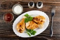 Bowls with ketchup, mayonnaise, salt and pepper, grilled chicken legs and parsley in dish, fork on wooden table. Top view