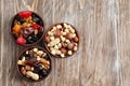 Bowls with mix of dried fruits, berries and nuts on wooden background, top view Royalty Free Stock Photo