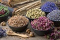 Bowls and mortars of medicinal herbs: lavender, cornflower, coneflower, daisies. Healing herbs assortment and old books Royalty Free Stock Photo