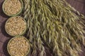 Bowls with oat grains and reap of oats on brown background. Top view