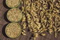 Bowls with oat grains and reap of oats on brown background. Top view