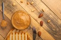 Bowls of peanut butter and peanuts on a dark wooden background from top view, rich breakfast