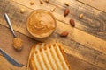 Bowls of peanut butter and peanuts on a dark wooden background from top view, rich breakfast Royalty Free Stock Photo