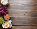 Bowls and pouches of various legumes: chickpeas, lentils, mung, red and white bean on a brown wooden background Royalty Free Stock Photo