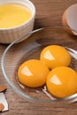 Bowls with raw egg yolks on wooden table, closeup Royalty Free Stock Photo