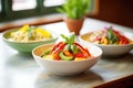 bowls of red, yellow, and green thai curry side by side