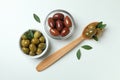 Bowls and spoon of olives, and leaves on white background Royalty Free Stock Photo