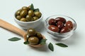 Bowls and spoon of olives, and leaves on white background Royalty Free Stock Photo