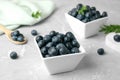 Bowls of tasty blueberries and spoon on marble table Royalty Free Stock Photo