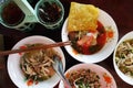 Bowls of Thai boat noodle with a condiment set.