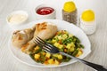 Bowls with ketchup, mayonnaise, salt and pepper, dish with fried chicken legs, vegetable mix, fork on table Royalty Free Stock Photo