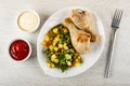 Bowls with ketchup, mayonnaise, dish with fried chicken legs, vegetable micx, fork on wooden table. Top view