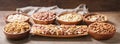 bowls of various mixed nuts on wooden background