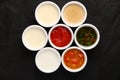 Bowls of various sauces on black background Royalty Free Stock Photo