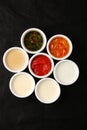 Bowls of various sauces on black background Royalty Free Stock Photo