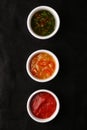 Bowls of various sauces on black background top view. set of sauces Royalty Free Stock Photo