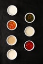 Bowls of various sauces on black background top view. set of sauces Royalty Free Stock Photo