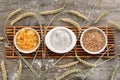 Bowls with wheat flour, grains and pasta on wooden table Royalty Free Stock Photo