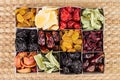 Box with assortment of dried fruits closeup on beige mat background. Royalty Free Stock Photo