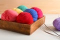 Box with balls of knitting yarn and needles on light table Royalty Free Stock Photo