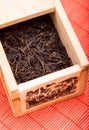 Box with black tea on red mat Royalty Free Stock Photo
