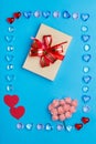 A box with a bow in a frame made of pebbles of hearts on a blue background. Royalty Free Stock Photo