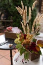 box with business cards on a black round table, a box with hydrangea, celosia flowers, elderberry branches and reeds