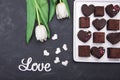 Box with chocolate sweets and tulips on dark background. Desert for Valentine Day Royalty Free Stock Photo