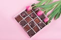 Box with chocolate sweets and tulips on pink background. Desert for Valentine Day Royalty Free Stock Photo