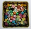 Box of colorful small origami lucky stars made of strips of paper