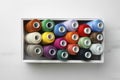 Box with colorful sewing threads on white marble table, top view Royalty Free Stock Photo