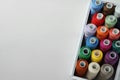 Box with colorful sewing threads on white marble table, top view. Space for text Royalty Free Stock Photo