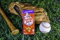 Box of cracker jack on old baseball glove with bat and ball