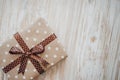 Box in craft paper, eco paper on the wooden table. Top view. Brown paper wrapped gift box with satin ribbon bow on a old Royalty Free Stock Photo