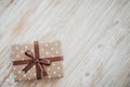 Box in craft paper, eco paper on the wooden table. Top view. Brown paper wrapped gift box with satin ribbon bow on a old Royalty Free Stock Photo