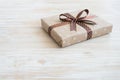 Box in craft paper, eco paper on the wooden table. Top view. Brown paper wrapped gift box with satin ribbon bow on a old rustic wo Royalty Free Stock Photo