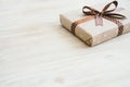 Box in craft paper, eco paper on the wooden table. Top view. Brown paper wrapped gift box with satin ribbon bow on a old rustic wo Royalty Free Stock Photo