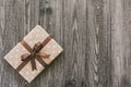 Box in craft paper, eco paper on the wooden table. Top view. Brown paper wrapped gift box with satin ribbon bow on a old rustic wo Royalty Free Stock Photo