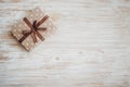 Box in craft paper, eco paper on the wooden table. Top view. Brown paper wrapped gift box with satin ribbon bow on a old rustic wo Royalty Free Stock Photo