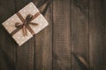 Box in craft paper, eco paper on the wooden table. Top view. Brown paper wrapped gift box with satin ribbon bow on a old rustic wo Royalty Free Stock Photo