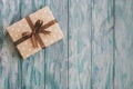 Box in craft paper, eco paper on the wooden table. Top view. Brown paper wrapped gift box with satin ribbon bow on a old rustic wo Royalty Free Stock Photo