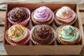 A box of cupcakes on a rustic wooden table. Perfect for bakery or dessert themes Royalty Free Stock Photo