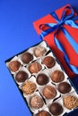 Box with delicious chocolate candies on blue background, above view Royalty Free Stock Photo