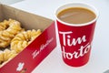 A Box of donuts with Honey Cruller Donuts and a Tim Hortons coffee Royalty Free Stock Photo