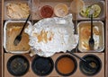 Box of fast food, empty plates with forks, sauces and aluminum bowls top view. Royalty Free Stock Photo