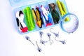 Box for fishing accessories with silicone baits inside, Jig hooks, braided reel on a white background Royalty Free Stock Photo