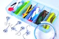 Box for fishing accessories with silicone baits inside, Jig hooks, braided reel on a white background close-up Royalty Free Stock Photo