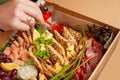 A box of food, cheese, breads, fish, shrimp. Food delivery for the company, romantic, office dinner at home. Beautiful composition