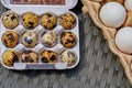 Box of fresh quail eggs with speckled shell with chicken eggs on the right Royalty Free Stock Photo