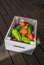 A box of fresh tomatoes, peppers, zucchini on a dark wooden surface Royalty Free Stock Photo